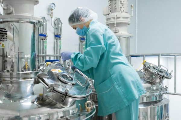 pharmaceutical-factory-woman-worker-protective-clothing-operating-production-line-sterile-environment