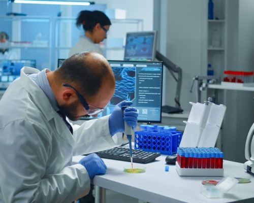 scientist-putting-blood-sample-from-test-tube-with-micropipette-petri-dish-analysing-chemical-reaction